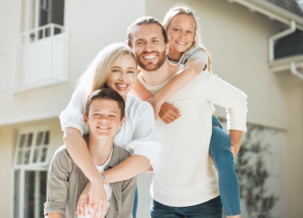 Nadie te ama como la familia te ama. Toma de una pareja y sus dos hijos parados juntos afuera.