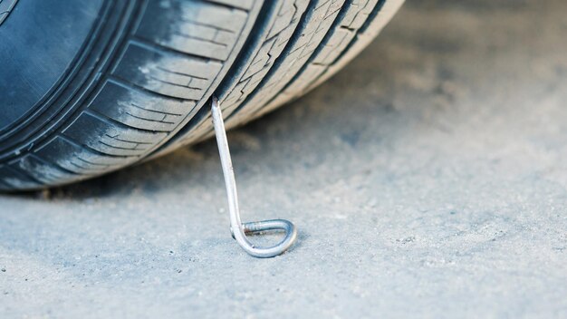 Nageln Sie mit einem Auto auf eine Asphaltstraße.