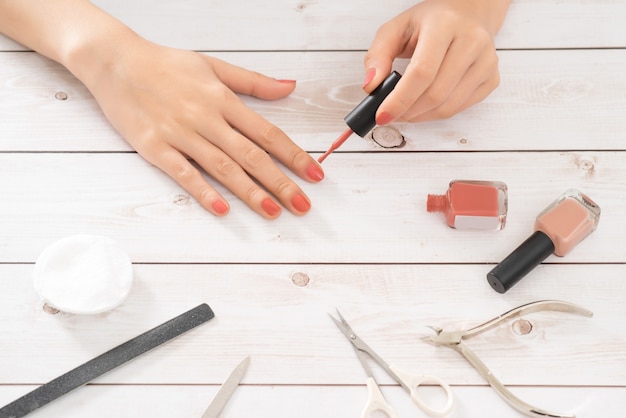 Nagelpflege und Maniküre. Schöne weibliche Hände mit rosa Nagellack