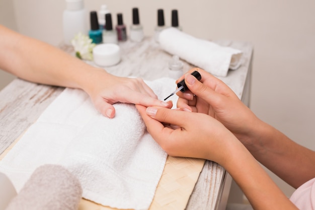 Nageltechniker, der Kunden eine Maniküre gibt