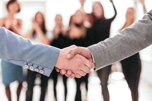 Nahansicht. Business-Handshake auf unscharfem Hintergrund des Business-Teams. Foto mit Textfreiraum