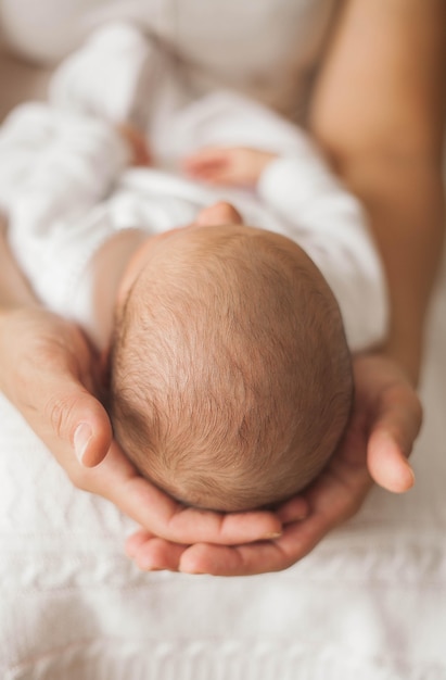 Nahansicht. Nettes Neugeborenes Baby, das in den Armen der Mutter schläft. Mutterschaft.