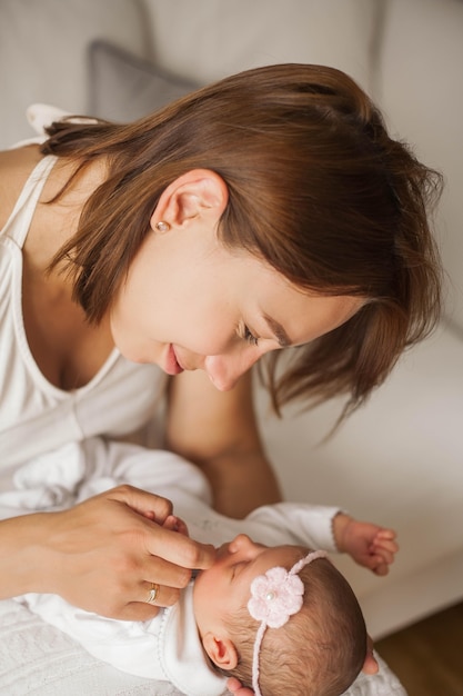 Nahansicht. Nettes Neugeborenes Baby, das in den Armen der Mutter schläft. Mutterschaft.