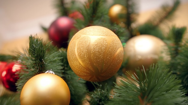 Nahaufnahme 4k-Aufnahmen von schönen goldenen sprudelnden Hängen und Drehen am Weihnachtsbaumast im Wohnzimmer