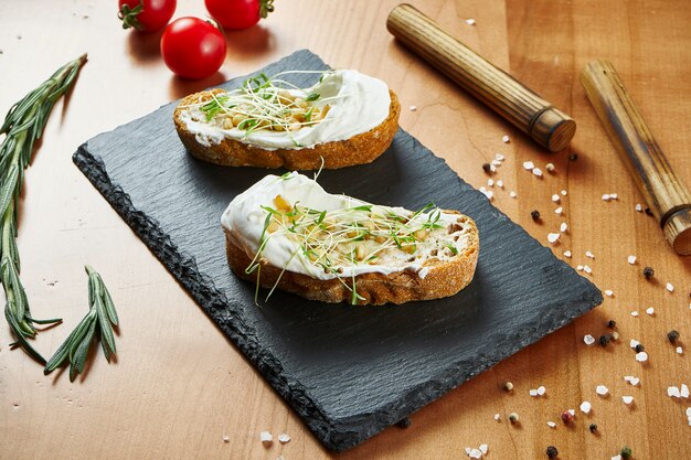 Foto nahaufnahme ansicht köstliche bruschetta mit frischkäse und mikrogrün auf holzoberfläche