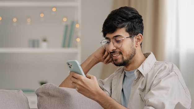 Nahaufnahme arabischer hispanischer Kerl junger Mann mit Brille bärtiger männlicher Benutzer Blogger sitzt zu Hause mit