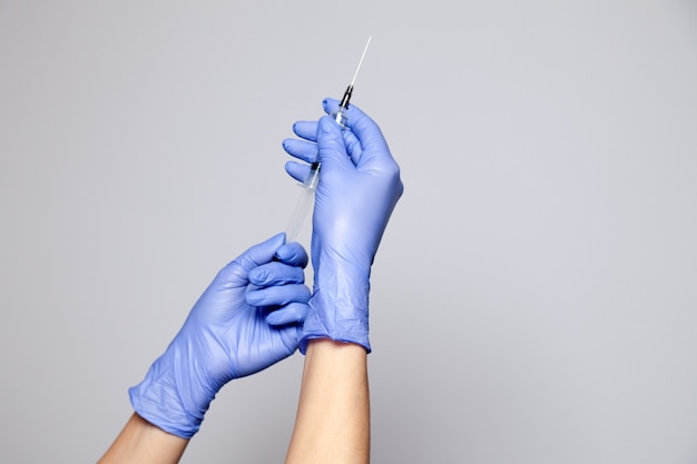 Nahaufnahme Arzt oder Krankenschwester Hände in Gummi Latex medizinische lila Handschuhe