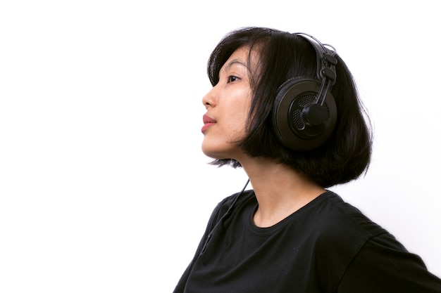 Nahaufnahme asiatische Frau mit Kopfhörern, die Musik auf weißem Raum genießen