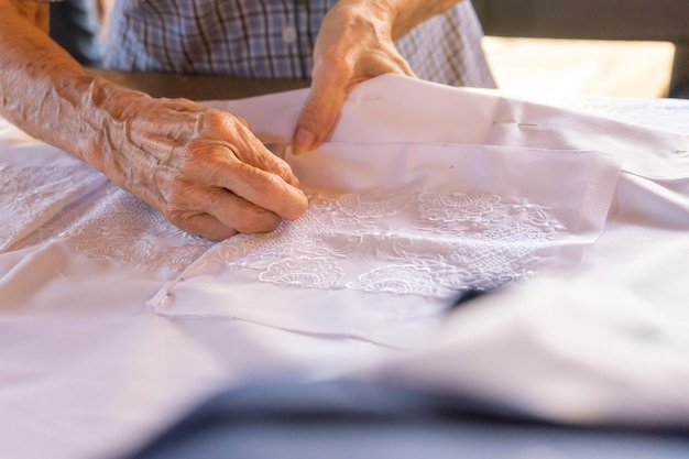 Nahaufnahme auf den Händen einer Näherin, die ein besticktes Guayabera-Hemd zusammenbaut