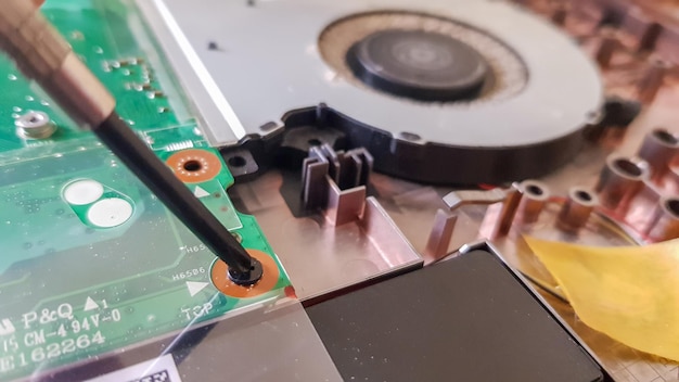 Nahaufnahme auf einem Laptopkühler. Wartung und Vorbeugung des Laptop-Kühlsystems. Reparaturkonzept für elektronische Geräte. Staub und Schmutz auf dem Computerlüfter. Demontage des Computers.