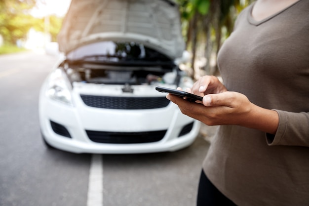 Nahaufnahme auf Frau Hand mit Telefonanruf Notfall-Auto-Service