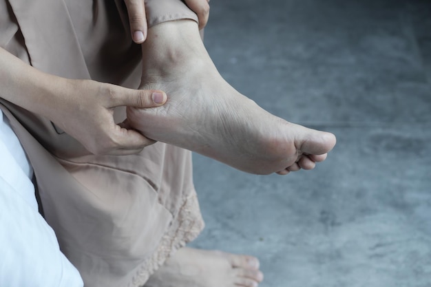 Nahaufnahme auf Frauenfüßen und Handmassage an der Verletzungsstelle
