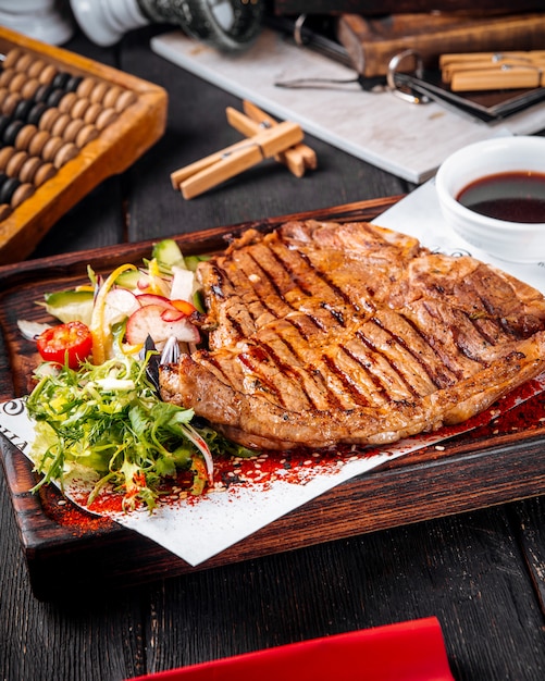 Nahaufnahme auf gegrilltem saftigem Steak mit Salat