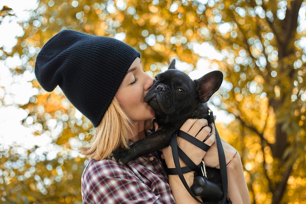 Nahaufnahme auf glücklicher junger Frau mit Hund draußen im Herbst