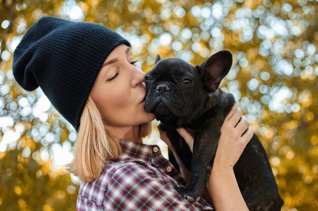 Nahaufnahme auf glücklicher junger Frau mit Hund draußen im Herbst