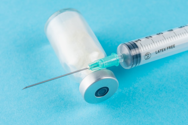 Nahaufnahme auf Impfstoffserum im Glasempfänger mit einer Spritze