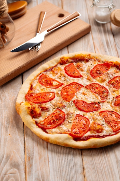 Nahaufnahme auf Margherita-Pizza mit Tomaten auf der Holzoberfläche