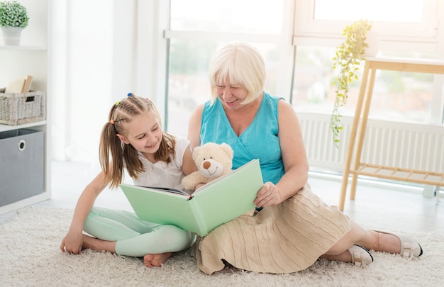 Nahaufnahme auf Oma, die Geschichten für kleine Enkelin liest