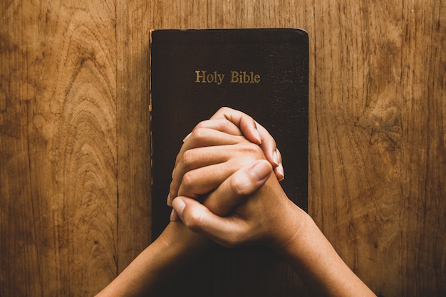 Nahaufnahme auf Person, die nahe der Bibel betet