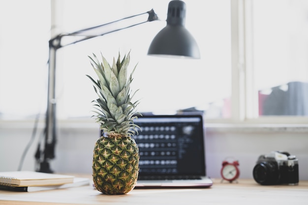 Nahaufnahme auf Schreibtisch im Büro mit Ananas