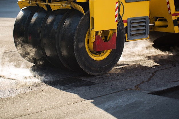 Nahaufnahme auf Straßenwalze, die Asphalt verdichtet