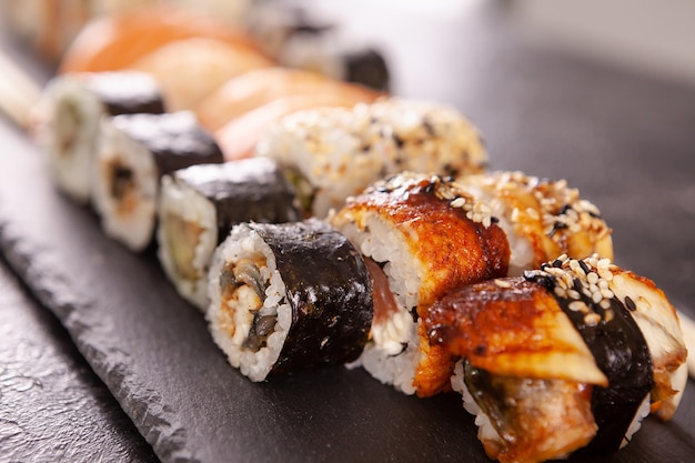 Nahaufnahme auf Teller Sushi auf dunklem Stein. Gesunde asiatische Küche