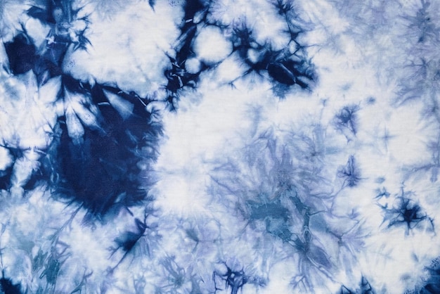 Nahaufnahme-Batikhemd mit indigoblauem Farbstoff auf weißem Stoff-Baumwollhintergrund auf Draufsicht
