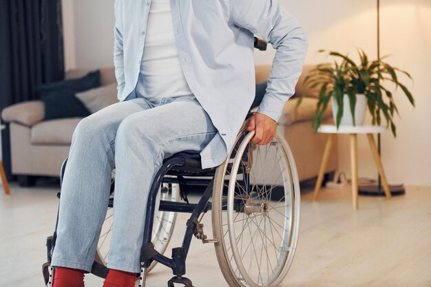 Nahaufnahme Behinderter Mann im Rollstuhl ist zu Hause