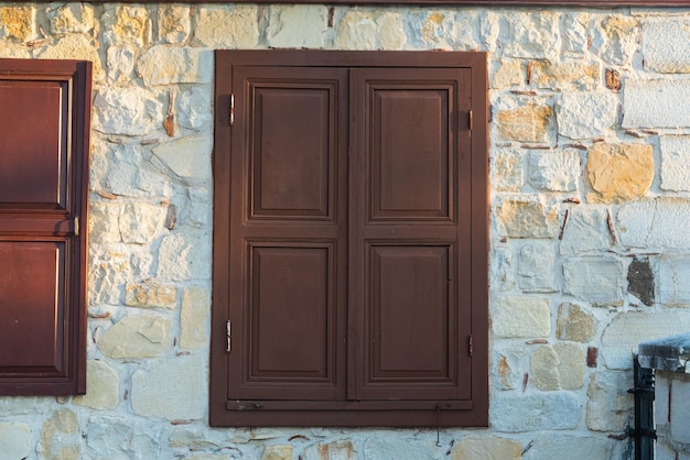 Nahaufnahme braunes Holzfenster in einem alten Steinhaus