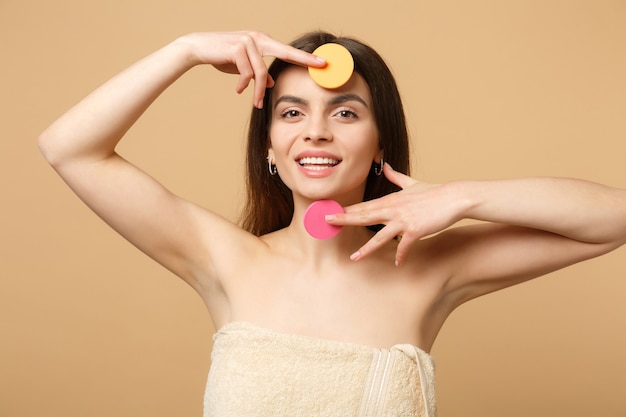 Nahaufnahme brünette halbnackte Frau mit perfekter Haut, nacktes Make-up entfernen isoliert auf beige pastellfarbener Wand