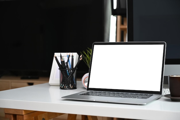 Nahaufnahme Computer Laptop Kaffeetasse und Bleistifthalter auf weißem Schreibtisch im Home Office