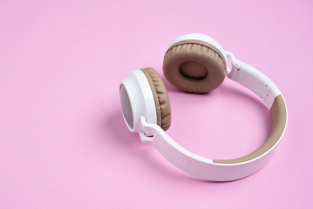 Nahaufnahme Cooler kabelloser Kopfhörer gegen auf rosa Hintergrund. Musikkonzept