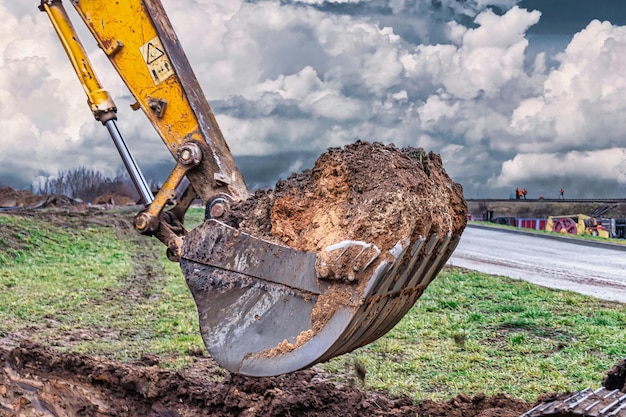 Nahaufnahme der Baggerschaufel auf der Baustelle Der Bagger gräbt einen Graben für unterirdische Versorgungsunternehmen Baumaschinen für Erdarbeiten