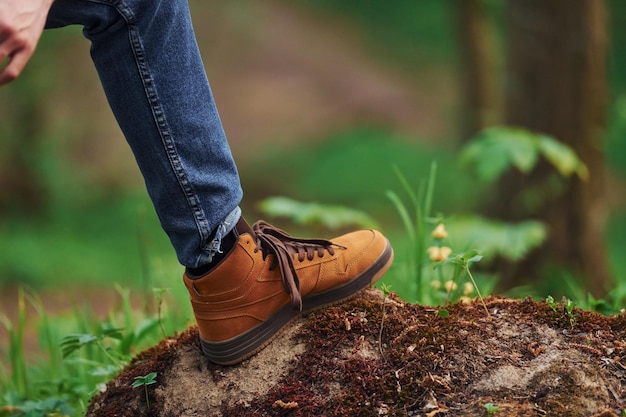 Nahaufnahme der Beine des Mannes auf dem Felsen im Wald Reisende haben einen Spaziergang