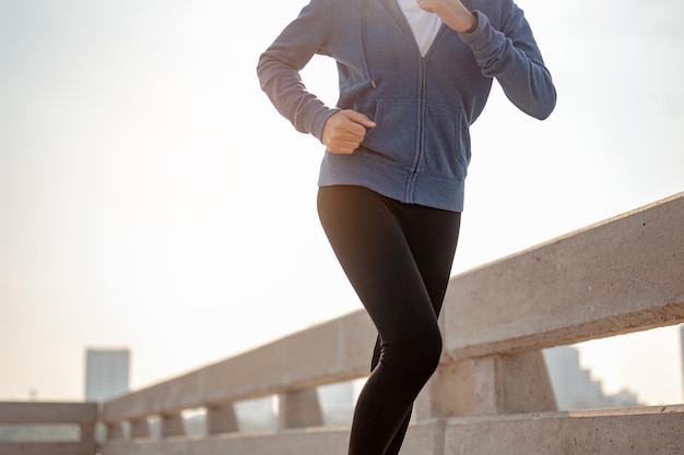 Nahaufnahme der Beine junge Frau Joggen im Morgentraining in der Stadt. Eine Stadt, die in der Hauptstadt gesund lebt. Bewegung, Fitness, Joggen, Laufen, Lifestyle, gesundes Konzept.