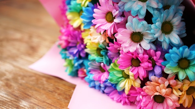 Nahaufnahme der Blüte Regenbogen blüht hellen Blumenstrauß auf Holzuntergrund