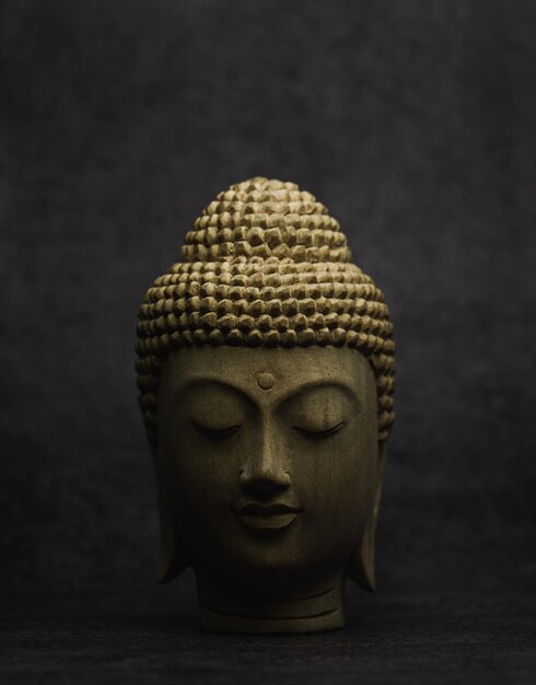 Foto nahaufnahme der buddha-statue vor grauem hintergrund