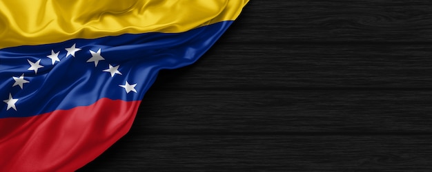 Nahaufnahme der Flagge der Vereinigten Staaten von Venezuela auf dem schwarzen Holzhintergrund 3d render