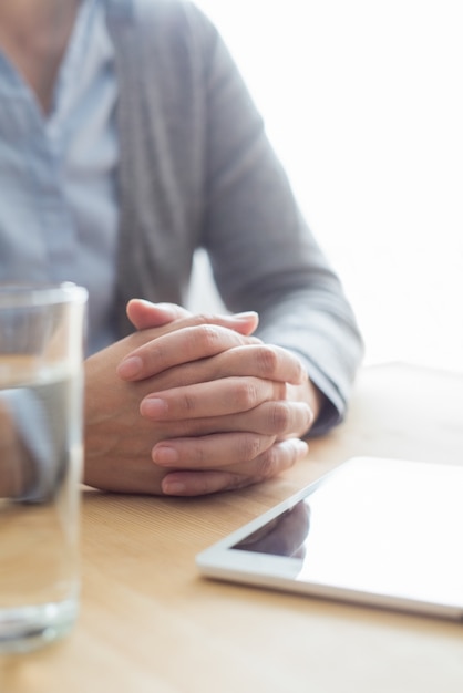 Nahaufnahme der Frau bei Tisch mit Wasser und Tablet