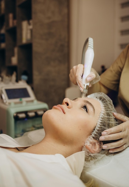 Nahaufnahme der Frau, die Hydro-Mikrodermabrasion-Peeling-Gesichtsbehandlung in der kosmetischen Schönheits-Spa-Klinik Hydra-Staubsauger-Peeling-Verjüngung und -Hydratation Kosmetologie-Gesichtshautpflege erhält