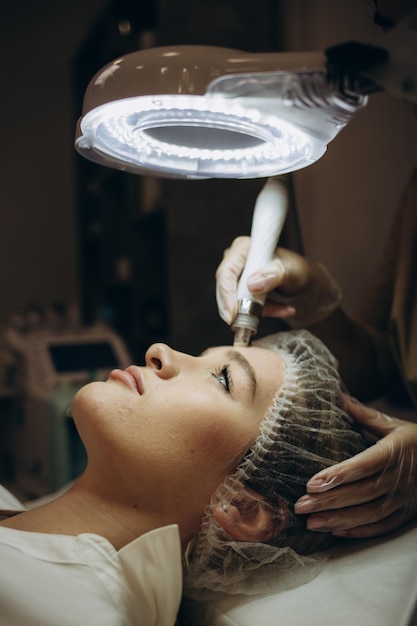Nahaufnahme der Frau, die Hydro-Mikrodermabrasion-Peeling-Gesichtsbehandlung in der kosmetischen Schönheits-Spa-Klinik Hydra-Staubsauger-Peeling-Verjüngung und -Hydratation Kosmetologie-Gesichtshautpflege erhält