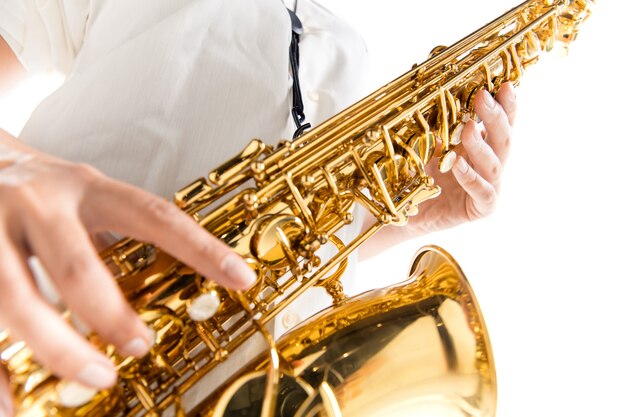 Nahaufnahme der Frau, die Saxophon spielt, isoliert auf weißem Studiohintergrund. Inspirierter Musiker, Details der Kunstbeschäftigung, Weltklassiker Instrument für Jazz und Blues. Konzept von Hobby, Kreativität.