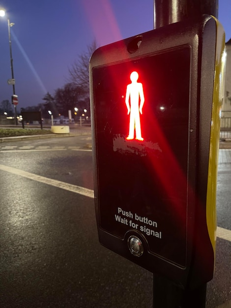 Nahaufnahme der Fußgängerampel, die nachts auf der Straße rot leuchtet