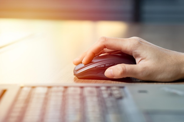 Nahaufnahme der Geschäftsfrau Hand mit Maus mit Computer-Laptop für die Arbeit im Büro.