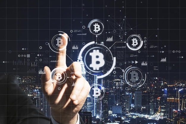 Nahaufnahme der Geschäftsmannhand, die auf abstraktes Bitcoin-Hologramm auf dunklem Nachtstadthintergrund zeigt Kryptowährungsfinanzierung und Blockchain-Konzept Doppelbelichtung