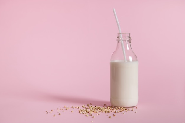 Nahaufnahme der Glasflasche mit Milch und Buchweizensamen