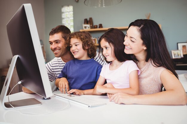 Nahaufnahme der glücklichen Familie schauend im Computer