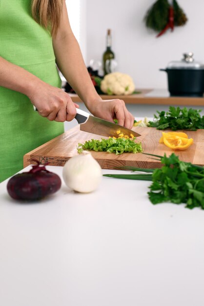 Nahaufnahme der Hände der Frau, die in der Küche kochen Hausfrau, die frischen Salat schneidet Vegetarisches und gesundes Kochkonzept