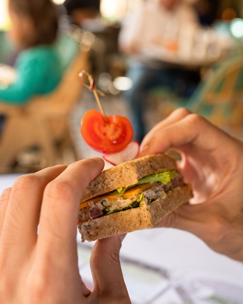 Nahaufnahme der Hände, die ein Sandwich halten