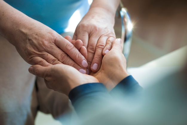 Nahaufnahme der Hände einer jungen und alten Frau. Das Konzept der Hilfe und Unterstützung für ältere Menschen.